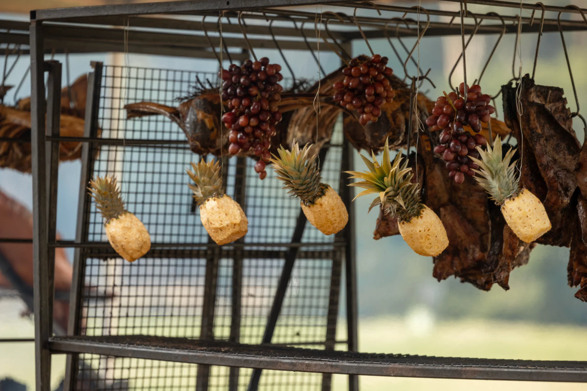Decorative elements including pineapples, grapes, and leaves hanging from a metal stand.