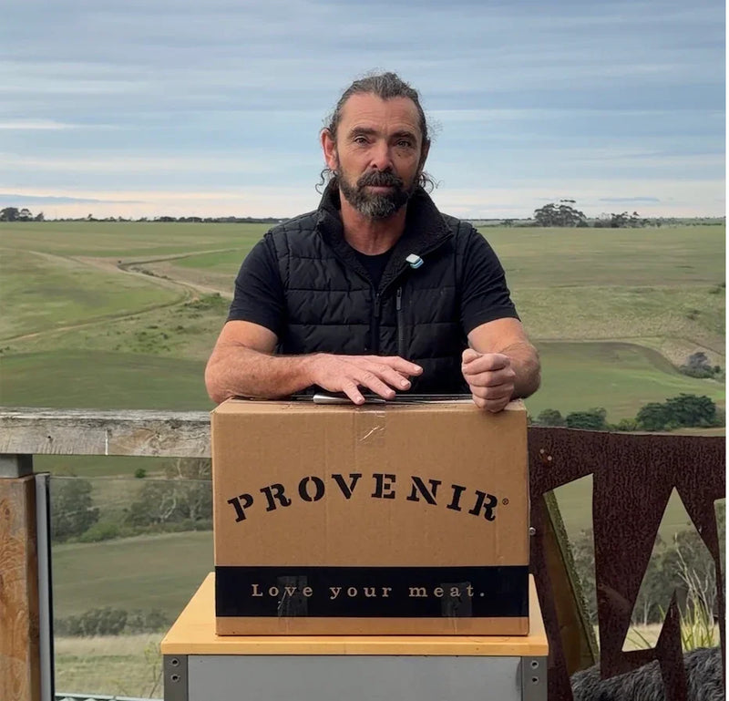 Man with Provenir meat box on farm, pasture-raised organic delivery